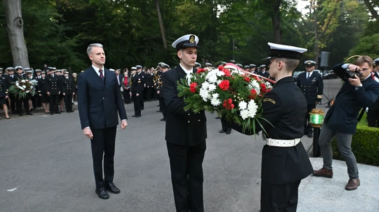 Wiceminister Arkadiusz Marchewka sklada w asyście studenta wieniec pod pomnikiem "Tym, którzy nie powrócili z morza" na Cmentarzu Centralnym