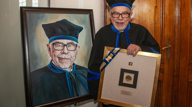 Laureat tytułu doktora honoris causa, prof. Stanisław Gucma przy swoim portrecie i z prezentem 