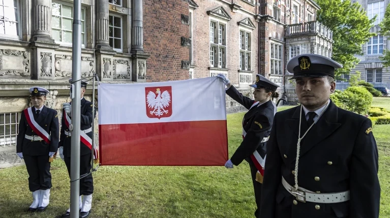 Studenci z Kompanii Honorowej PM prezentują banderę przed budynkiem uczelni w dniu Święta Szkoły