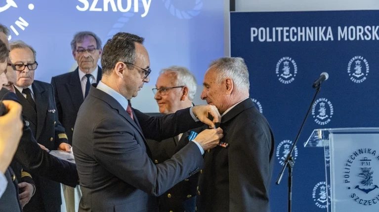 Minister Infrastruktury Dariusz Klimczak przypina honorowe odznaczenie Ligi Morskiej i Rzecznej - Krzyż „Pro Mari Nostro” Jerzemu Hajdukukowi 