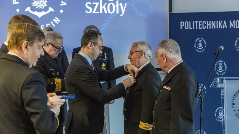 Minister Infrastruktury Dariusz Klimczak przypina honorowe odznaczenie Ligi Morskiej i Rzecznej - Krzyż „Pro Mari Nostro” Kanclerzowi PM Andrzejowi Durajczykowi