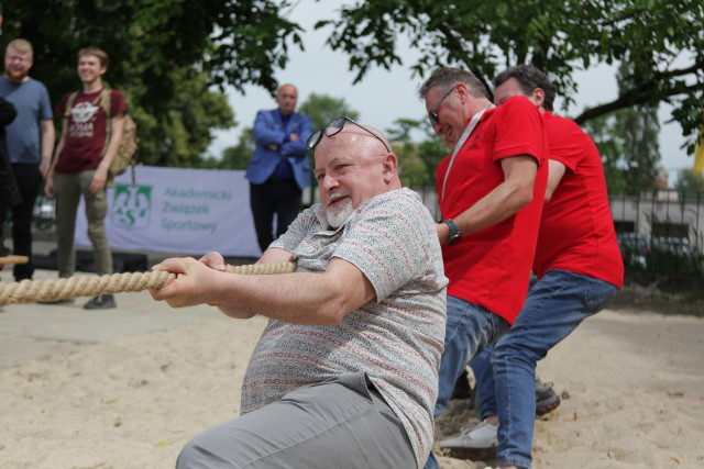 Pracownicy i studenci  PM przeciągający linę podczas zawodów sportowych na pikniku podczas Święta Szkoły