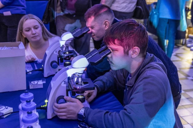 Studenci przy mikroskopach na stoisku Morskiego Centrum Nauki podczas obchodów Międzynarodowego Dnia Studentów ma PM
