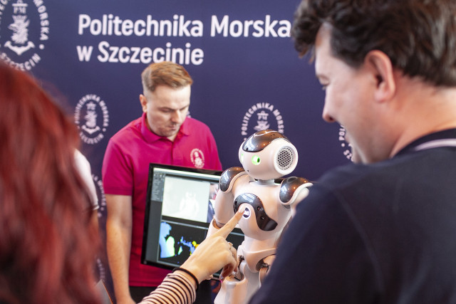 Dr inż. Łukasz Nozdrzykowski  z WIiT demonstruje robota humanoidalnego uczennicom szkół średnich na targach edukacyjnych Edu Day 2023 w Szczecinie