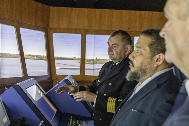 Rektor PM Wojciech Ślączka objaśnia gościom specyfikę symulatora mostka nawigacyjnego w CIRM