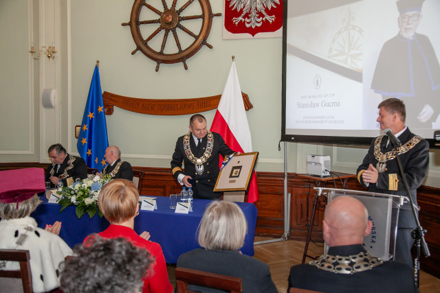 Rektor PM pokazuje prezent dla DHC prof. Stanisława Gucmy