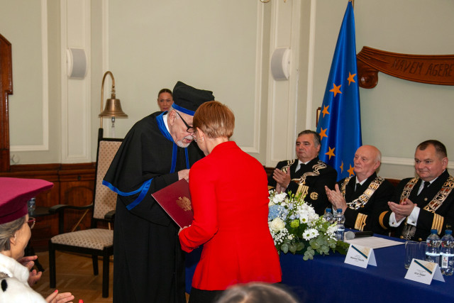 Prof. Stanisław Gucma przyjmuje gratulacje od przedstawicielki Ministra Nauki