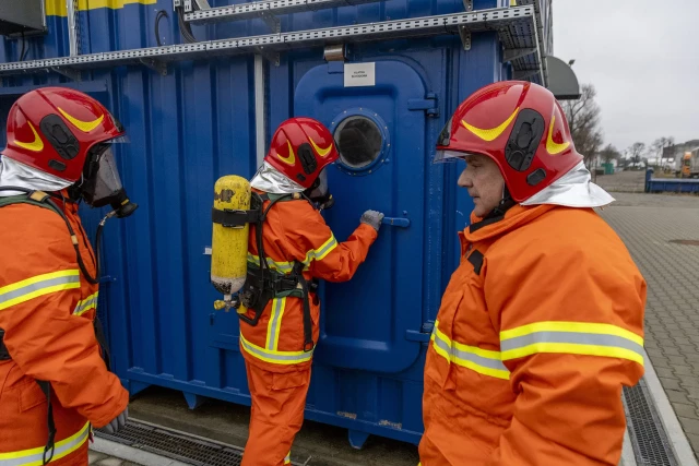 Dwoje studentów i instruktor przed komorą rozgorzeniowo-dymową