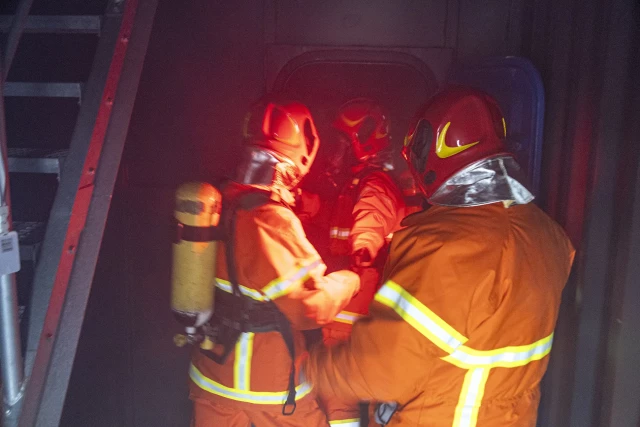 Dwoje studentów i instruktor w komorze rozgorzeniowo-dymowej