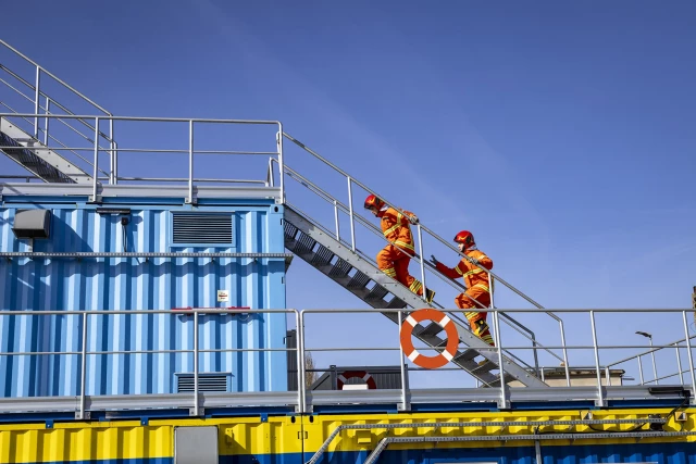 Grupa studentów wchodzi do komory rozgorzeniowo-dymowej