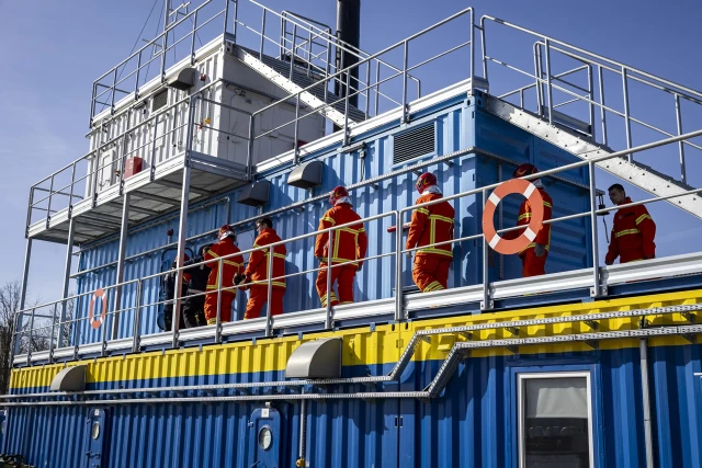 Grupa studentów wchodzi do komory rozgorzeniowo-dymowej