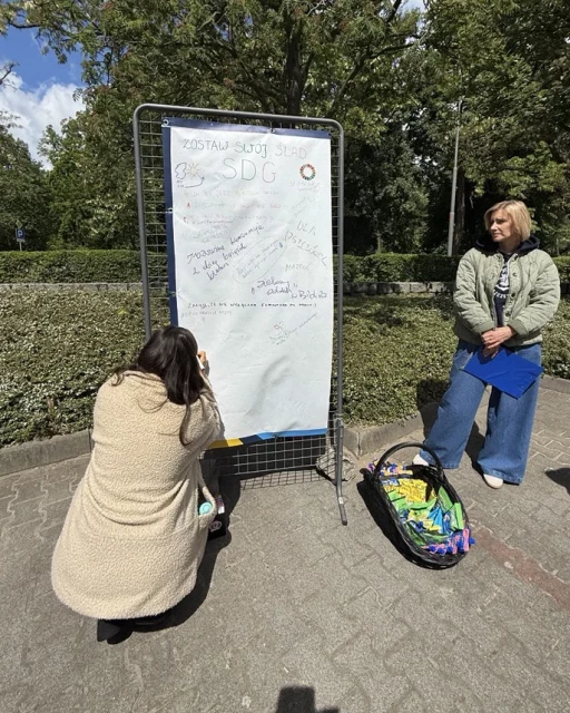 Student pisze hasło na banerze w strefie SDG