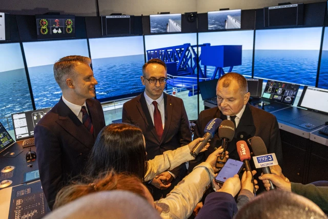 Wiceminister Infrastruktury Arkadiusz Marchewka, Minister Infrastrukury Dariusz Klimczak i Rektor PM Wojciech Ślączka przy symulatorze mostka nawigacyjnego podczas otwarcia Akademickiego Centrum Symulatorów