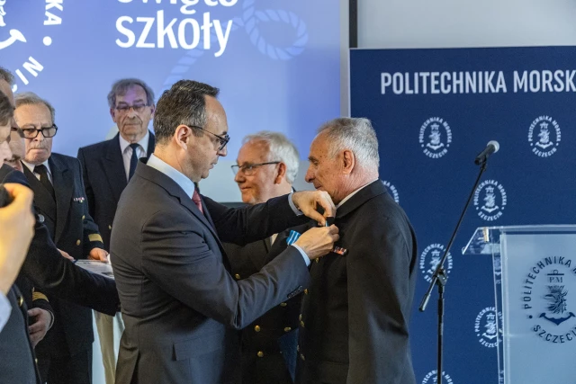 Minister Infrastruktury Dariusz Klimczak przypina honorowe odznaczenie Ligi Morskiej i Rzecznej - Krzyż „Pro Mari Nostro” Jerzemu Hajdukukowi 
