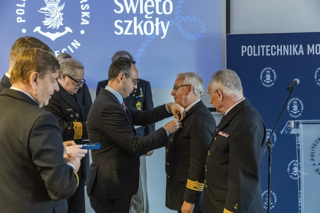 Minister Infrastruktury Dariusz Klimczak przypina honorowe odznaczenie Ligi Morskiej i Rzecznej - Krzyż „Pro Mari Nostro” Kanclerzowi PM Andrzejowi Durajczykowi