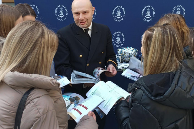 Rafał Zaweracz z Dział Promocji PM rozmawia z uczniami szkoły średniej na targach edukacyjnych w Radomiu