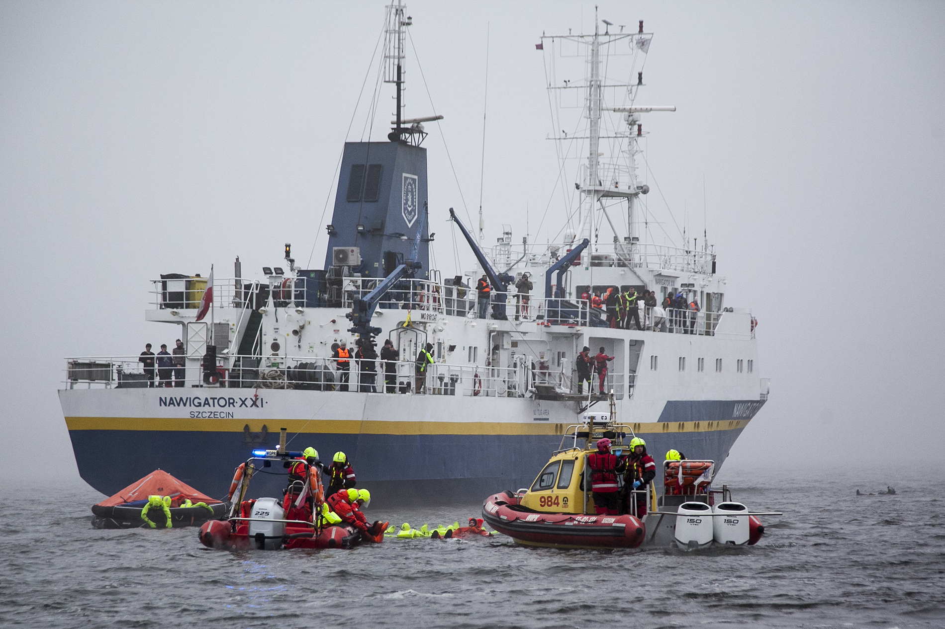 The rescue team in the boat with the ship Nawigator XXI in the background