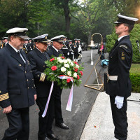 Przedstawiciele środowiska morskiego w asyście studenta PM składają wieniec pod pomnikiem "Tym, którzy nie powrócili z morza"