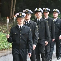 Studenci PM w mundurach z pochodniami podczas uroczystości pod pomnikiem "Tym, którzy nie powrócili z morza" na Cmentarzu Centralnym