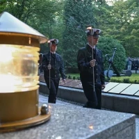 Studenci PM w mundurach z pochodniami podczas uroczystości pod pomnikiem "Tym, którzy nie powrócili z morza" na Cmentarzu Centralnym