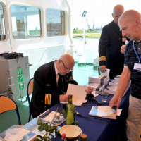 prof. kpt. ż.w Aleksander Walczak wpisuje dedykacje w książki