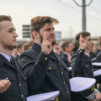 Mundurowi studenci I roku PM, trzymając czapki na dłoni ślubują podczas uroczystości inauguracji nowego roku akademickiego 2023/24