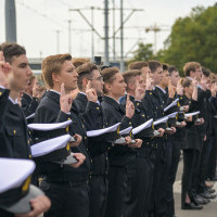 Mundurowi studenci I roku PM, trzymając czapki na dłoni ślubują podczas uroczystości inauguracji nowego roku akademickiego 2023/24