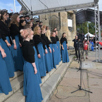 Dyrygentka Chóru PM Sylwia Fabiańczyk-Makuch dyryguje chórem podczas uroczystości inauguracji nowego roku akademickiego 2023/24 na PM