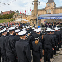Studenci w mundurach stoją przed trybuną honorową z gośćmi przybyłymi na inaugurację roku akademickiego Politechniki Morskiej w Szczecinie