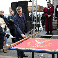 Jeden z fundatorów przybija symboliczny gwóźdź do plakietki fundatorskiej na drzewcu sztandaru Politechniki Morskiej