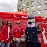 Maskotka PM morświn Michu przy namiocie partnera pikniku Banku Peakao