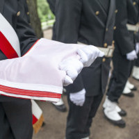 Członek Pocztu sztandarowego Politechniki Morskiej w Szczecinie trzyma złożoną flagę państwową