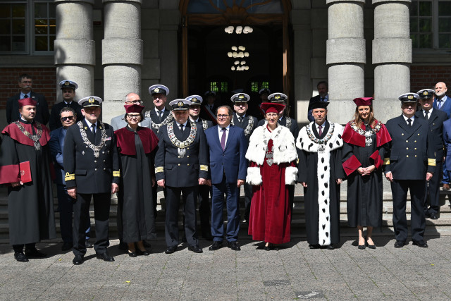 Przedstawiciele władz zachodniopomorskich uczelni i zaproszeni goście oglądają przed budynkiem AMS musztrę paradną z okazji 75-lecia szkolnictwa morskiego na Pomorzu Zachodnim