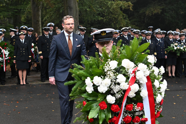 Wojewoda Zachodniopomorski Zbigniew Bogucki w asyście studenta PM składa wieniec pod pomnikiem "Tym, którzy nie powrócili z morza"