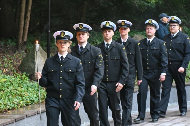 Studenci PM w mundurach z pochodniami podczas uroczystości pod pomnikiem "Tym, którzy nie powrócili z morza" na Cmentarzu Centralnym