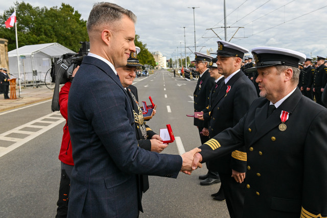 Wręczanie odznaczenia przez Sekretarza Stanu A. Marchewkę i Rektora PM W.  Ślączkę