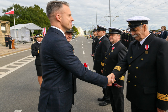Wręczanie odznaczenia przez Sekretarza Stanu A. Marchewkę i Rektora PM W.  Ślączkę