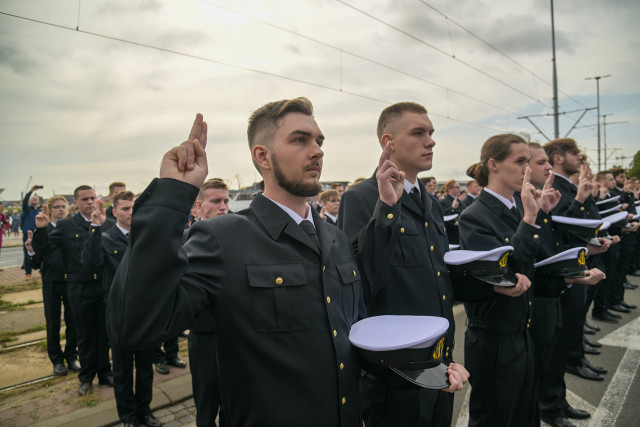 Mundurowi studenci I roku PM, trzymając czapki na dłoni ślubują podczas uroczystości inauguracji nowego roku akademickiego 2023/24