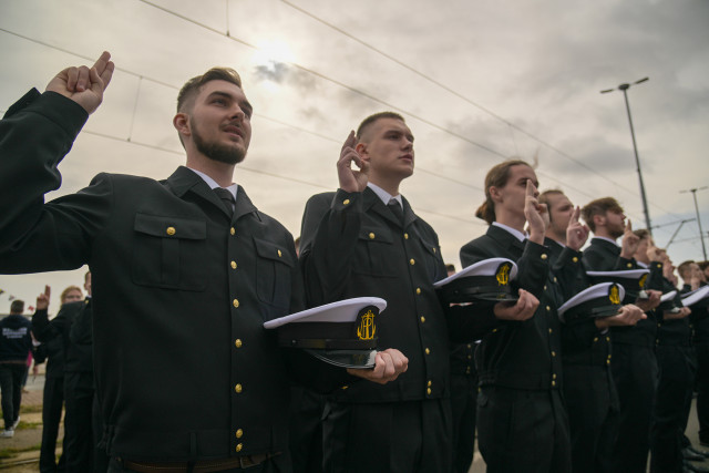 Mundurowi studenci I roku PM, trzymając czapki na dłoni ślubują podczas uroczystości inauguracji nowego roku akademickiego 2023/24