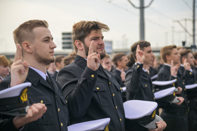 Mundurowi studenci I roku PM, trzymając czapki na dłoni ślubują podczas uroczystości inauguracji nowego roku akademickiego 2023/24