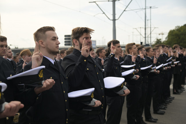 Mundurowi studenci I roku PM, trzymając czapki na dłoni ślubują podczas uroczystości inauguracji nowego roku akademickiego 2023/24