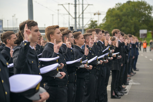Mundurowi studenci I roku PM, trzymając czapki na dłoni ślubują podczas uroczystości inauguracji nowego roku akademickiego 2023/24
