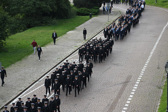 Studenci I roku Politechniki Morskiej w Szczecinie schodzą ulicą u stóp Wałów Chrobrego na uroczystość inauguracji roku akademickiego