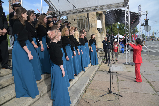 Dyrygentka Chóru PM Sylwia Fabiańczyk-Makuch dyryguje chórem podczas uroczystości inauguracji nowego roku akademickiego 2023/24 na PM