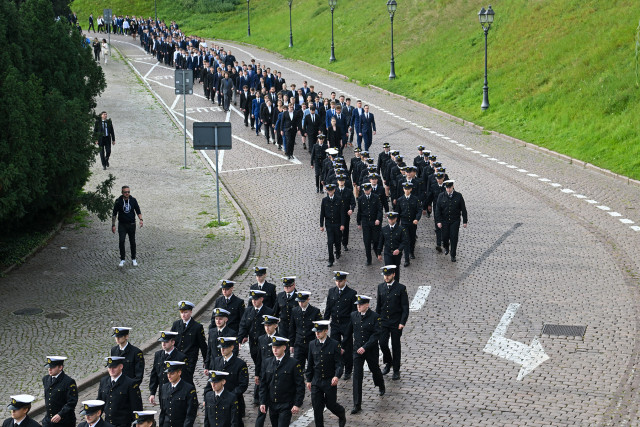 Studenci I roku Politechniki Morskiej w Szczecinie schodzą ulicą u stóp Wałów Chrobrego na uroczystość inauguracji roku akademickiego