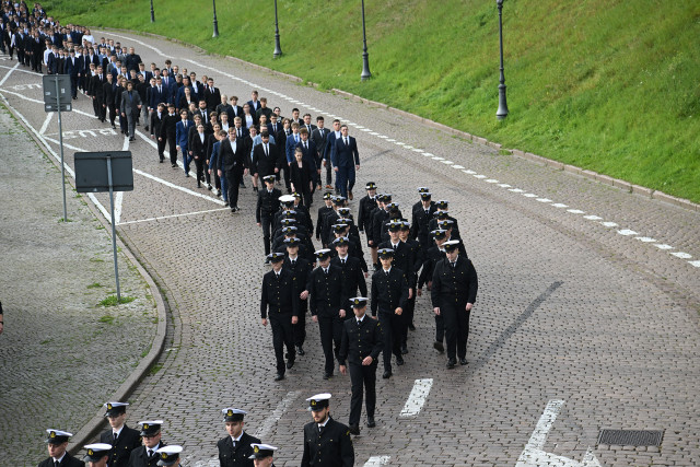 Studenci I roku Politechniki Morskiej w Szczecinie schodzą ulicą u stóp Wałów Chrobrego na uroczystość inauguracji roku akademickiego