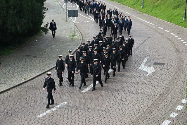 Studenci I roku Politechniki Morskiej w Szczecinie schodzą ulicą u stóp Wałów Chrobrego na uroczystość inauguracji roku akademickiego
