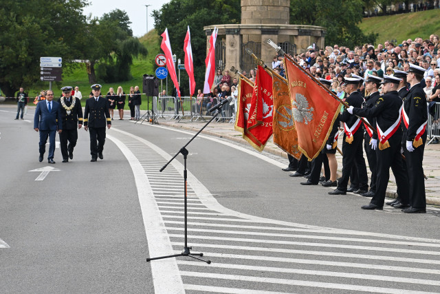 Rektor PM Wojciech Ślączka i Sekretarz Stanu Marek Gróbarczyk zbliżają się do historycznych pocztów sztandarowych szczecińskich szkół morskich