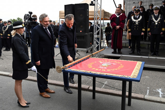 Jeden z fundatorów przybija symboliczny gwóźdź do plakietki fundatorskiej na drzewcu sztandaru Politechniki Morskiej