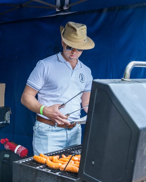 Student przy grillu podczas pikniku z okazji Święta Szkoły PM